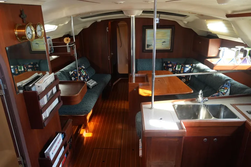 Andiamo Yacht Photos Pics Interior of a 1998 Hunter 410 sailboat with cozy seating and wooden finishes.