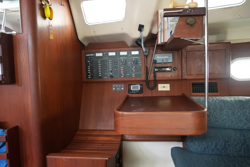 Andiamo Yacht Photos Pics Interior of a 1998 Hunter 410 sailboat with navigation panel and seating area.