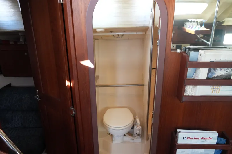 Andiamo Yacht Photos Pics 1998 Hunter 410 yacht interior with wooden cabinetry and compact bathroom.