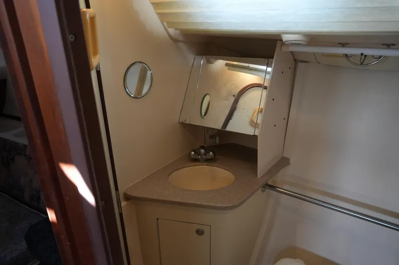 Andiamo Yacht Photos Pics 1998 Hunter 410 yacht bathroom with sink, mirror, and storage cabinet.
