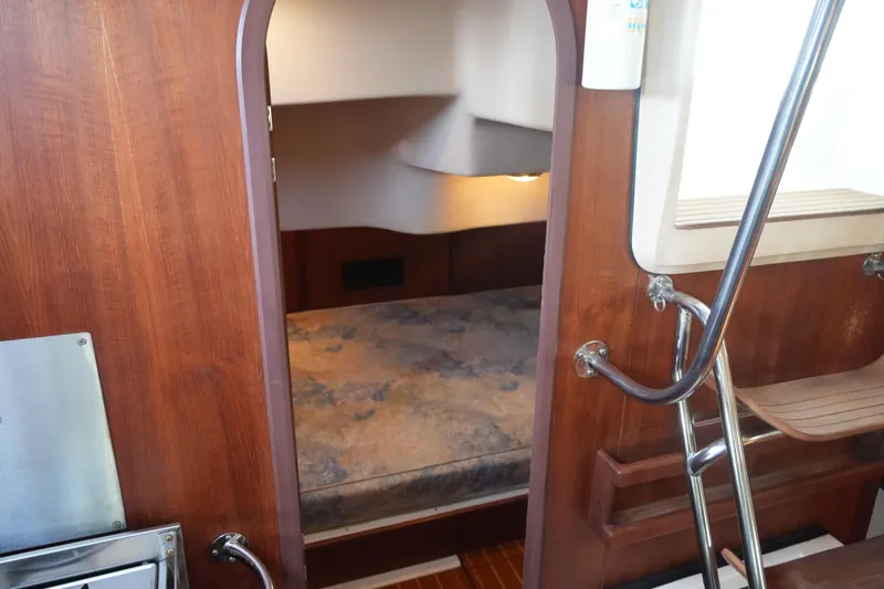 Andiamo Yacht Photos Pics Interior cabin of a 1998 Hunter 410 sailboat with wooden finish and cozy sleeping area.