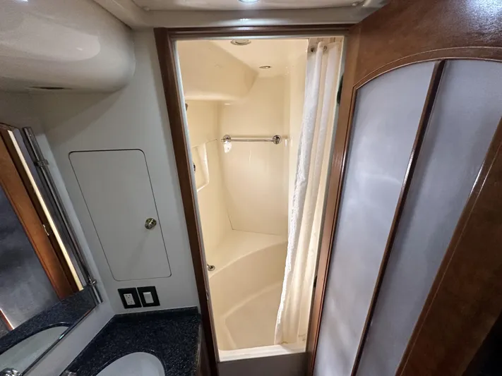 Bootlegger Yacht Photos Pics 1999 Carver 530 Voyager Pilothouse bathroom with shower, sink, and wooden cabinetry.
