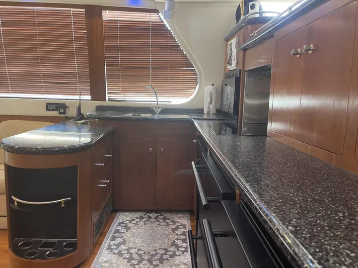 Bootlegger Yacht Photos Pics Luxurious kitchen interior of 1999 Carver 530 Voyager Pilothouse with wood cabinetry and granite countertops.