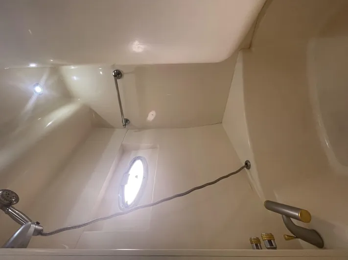 Bootlegger Yacht Photos Pics Shower area in 1999 Carver 530 Voyager Pilothouse with porthole and handheld showerhead.