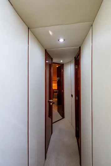 You Go Girl! Yacht Photos Pics Narrow hallway inside 2000 Fairline Squadron 52 yacht, featuring sleek wooden doors and modern lighting.