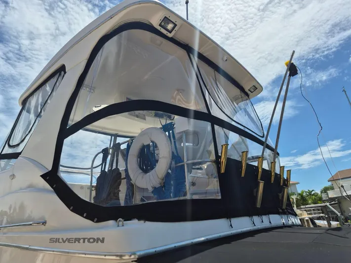 Freebyrd II Yacht Photos Pics 2002 Silverton 38 Convertible boat with clear enclosure and fishing rod holders.