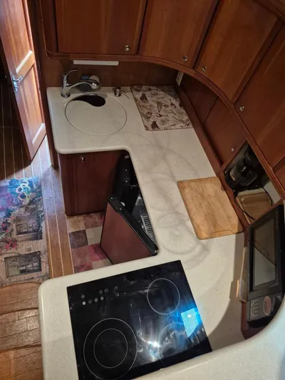 Freebyrd II Yacht Photos Pics 2002 Silverton 38 Convertible yacht kitchen with stove, sink, and wooden cabinetry.