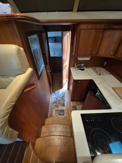 Freebyrd II Yacht Photos Pics Interior of 2002 Silverton 38 Convertible yacht with wooden cabinetry and compact kitchen.