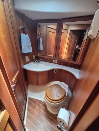 Freebyrd II Yacht Photos Pics 2002 Silverton 38 Convertible yacht bathroom with wooden cabinetry and compact design.