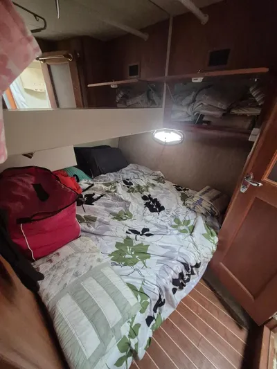 Freebyrd II Yacht Photos Pics Cozy cabin interior of 2002 Silverton 38 Convertible with bed and storage shelves.