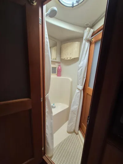 Freebyrd II Yacht Photos Pics Shower area in 2002 Silverton 38 Convertible boat with curtain and wooden door.