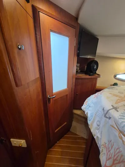 Freebyrd II Yacht Photos Pics Interior of 2002 Silverton 38 Convertible yacht with wooden door and nautical-themed bedding.