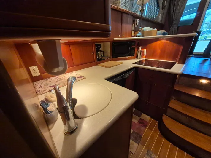 Freebyrd II Yacht Photos Pics 2002 Silverton 38 Convertible yacht kitchen with sink, stove, and wooden cabinetry.