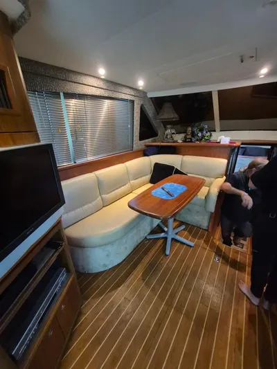 Freebyrd II Yacht Photos Pics Interior of 2002 Silverton 38 Convertible yacht with cozy seating and wooden flooring.