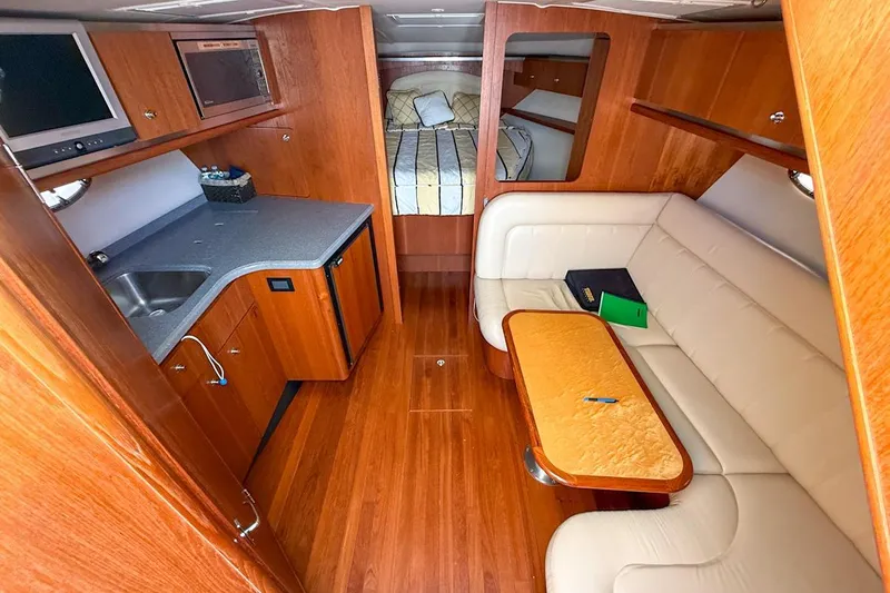  Yacht Photos Pics Luxurious 2006 Tiara 3600 yacht interior with kitchenette, seating, and cozy sleeping area.