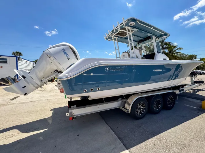  Yacht Photos Pics 2025 Edgewater 325CC boat on trailer, featuring Yamaha outboard motor, under clear blue sky.