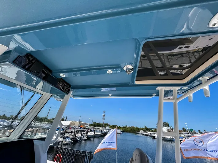  Yacht Photos Pics 2025 Edgewater 325CC boat interior with blue ceiling and marina view.