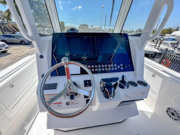  Yacht Photos Pics 2025 Edgewater 325CC boat dashboard with steering wheel and modern controls.