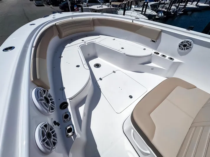  Yacht Photos Pics 2025 Edgewater 325CC boat interior with beige seating and speakers, docked at a marina.