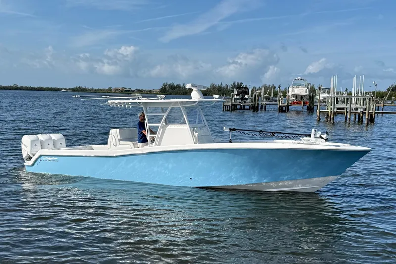  Yacht Photos Pics 2021 Invincible 36 CC boat on water, featuring a sleek blue hull and triple engines.