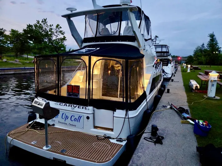  Yacht Photos Pics 2005 Carver 38 Super Sport yacht docked, illuminated interior, "For Sale" sign visible.