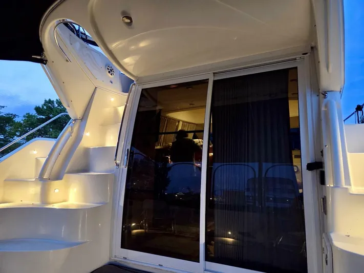  Yacht Photos Pics 2005 Carver 38 Super Sport yacht with illuminated stairs and sliding glass door at dusk.