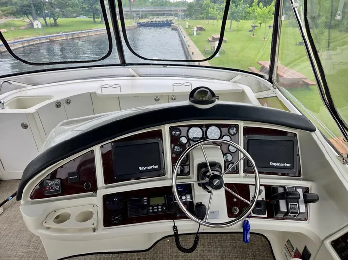  Yacht Photos Pics Helm of 2005 Carver 38 Super Sport with Raymarine navigation, steering wheel, and control panel.