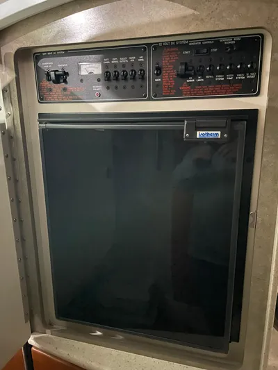 "abe Froman" Yacht Photos Pics Control panel and refrigerator in 2006 Formula 330 Sun Sport boat interior.