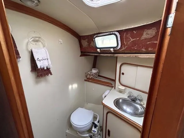 Equinox Yacht Photos Pics 1980 Irwin 46 Ketch bathroom with sink, toilet, and porthole window.