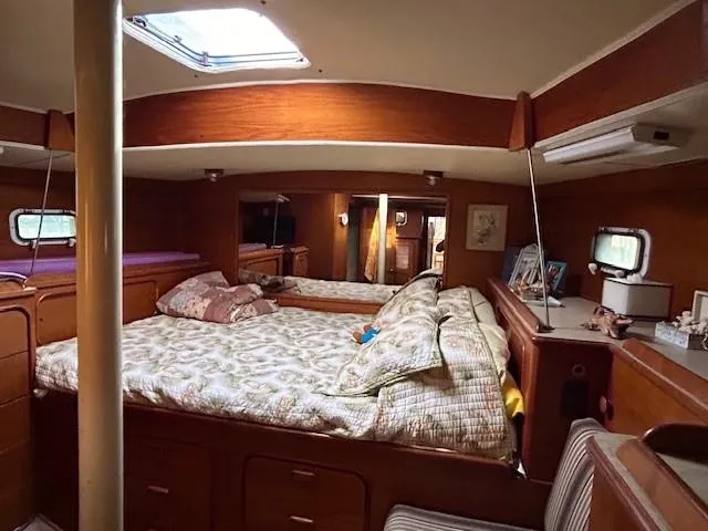 Equinox Yacht Photos Pics Interior of 1980 Irwin 46 Ketch sailboat with cozy bedroom and wooden furnishings.