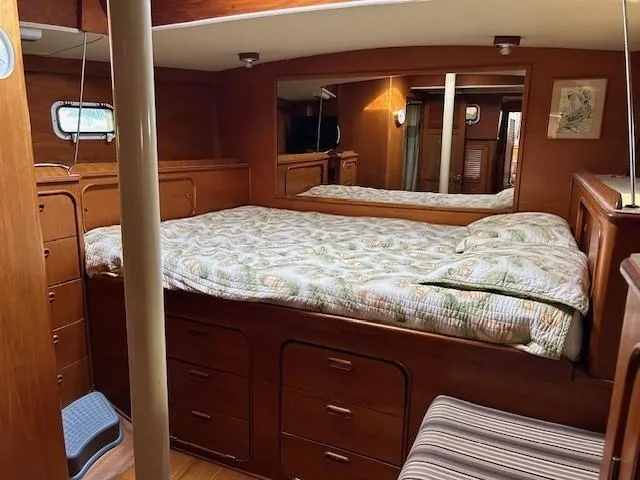 Equinox Yacht Photos Pics Cozy 1980 Irwin 46 Ketch cabin with wooden interior and comfortable bedding.