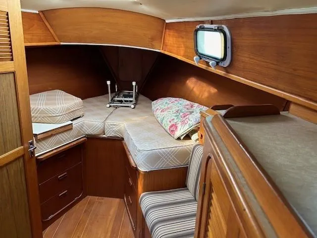 Equinox Yacht Photos Pics 1980 Irwin 46 Ketch cabin interior with wooden finish and cozy bedding.