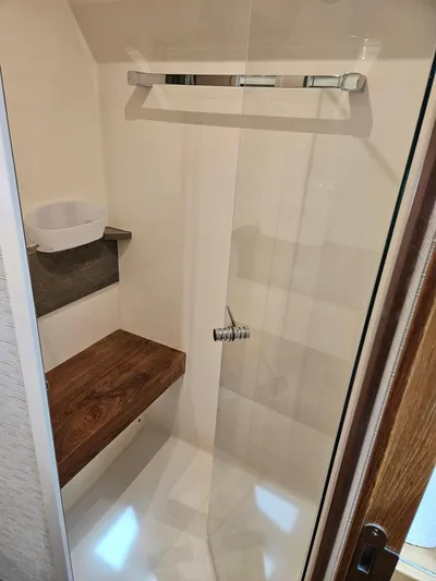  Yacht Photos Pics 2022 Tiara Yachts C39 Coupe shower with wooden bench and modern fixtures.