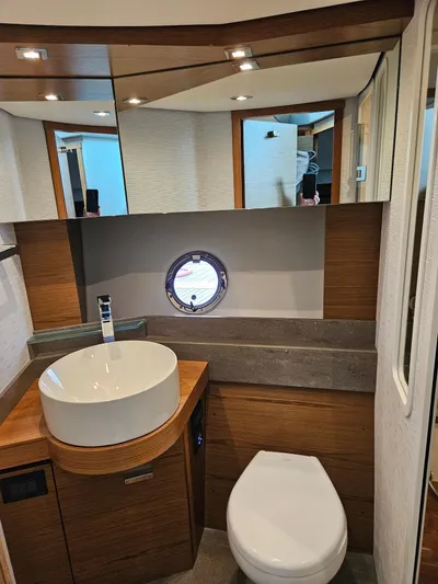  Yacht Photos Pics 2022 Tiara Yachts C39 Coupe bathroom with modern fixtures and porthole window.