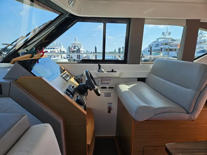  Yacht Photos Pics 2022 Tiara Yachts C39 Coupe interior with helm and seating, docked at marina.