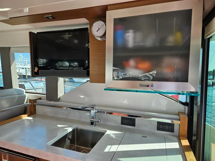  Yacht Photos Pics Interior of 2022 Tiara Yachts C39 Coupe featuring modern kitchen with sink and TV.