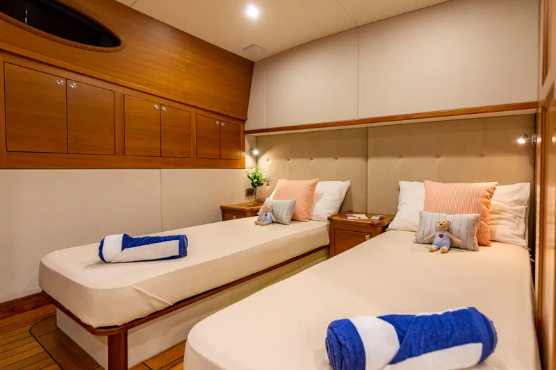 Independence Yacht Photos Pics Luxurious twin cabin in 2021 Palm Beach Motor Yachts PB65, featuring elegant wood finishes.