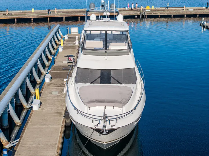 Compound Interest Yacht Photos Pics Prestige 630 Yacht 2018 docked at marina, calm blue water, clear sky.