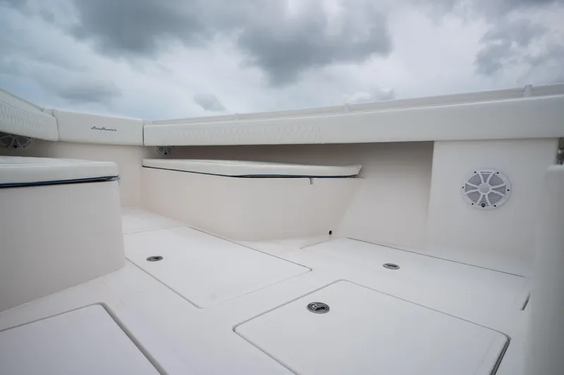 Yacht Photos Pics 2016 SeaHunter 45 boat interior with white seating and storage compartments under cloudy sky.