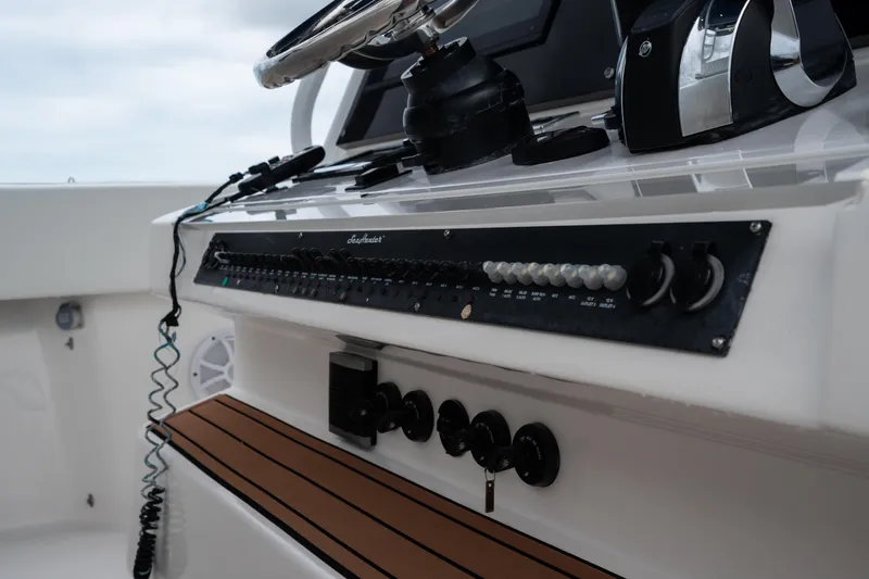  Yacht Photos Pics Control panel of a 2016 SeaHunter 45 boat with steering wheel and switches.