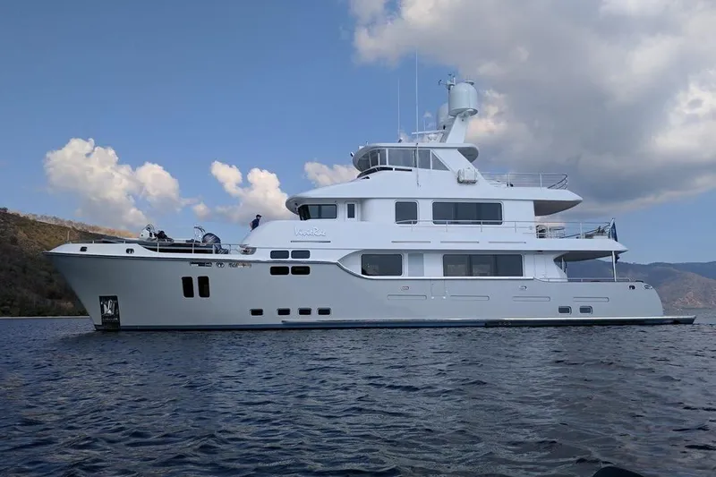  Yacht Photos Pics Luxurious 2017 Nordhavn 96 yacht cruising on calm waters under a partly cloudy sky.