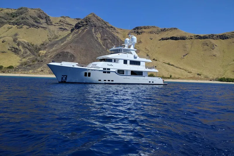  Yacht Photos Pics Luxurious 2017 Nordhavn 96 yacht cruising near scenic coastal cliffs.