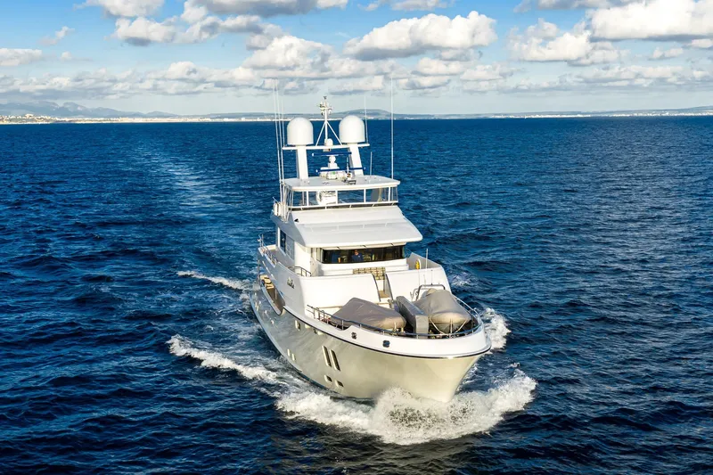  Yacht Photos Pics Luxurious 2017 Nordhavn 96 yacht cruising on open sea under blue sky.