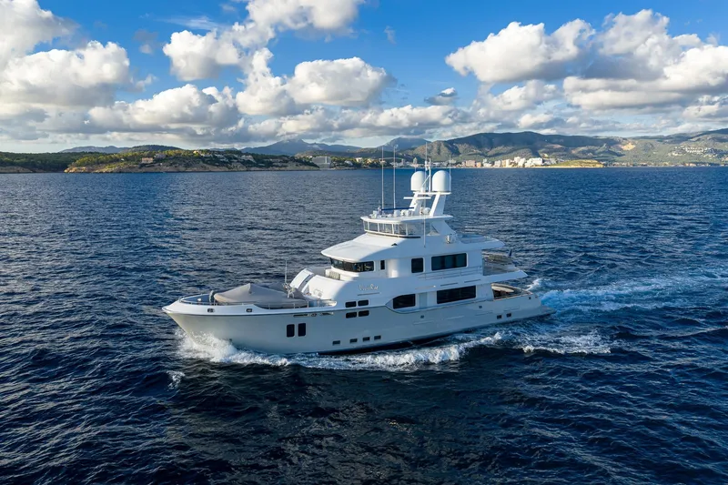  Yacht Photos Pics Luxurious 2017 Nordhavn 96 yacht cruising on open sea under blue sky.