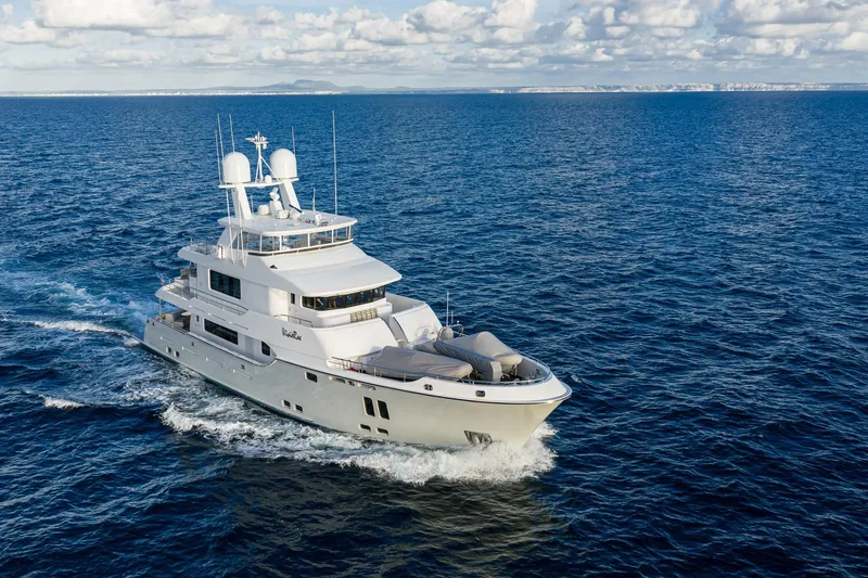  Yacht Photos Pics Luxurious 2017 Nordhavn 96 yacht cruising on open ocean under cloudy sky.