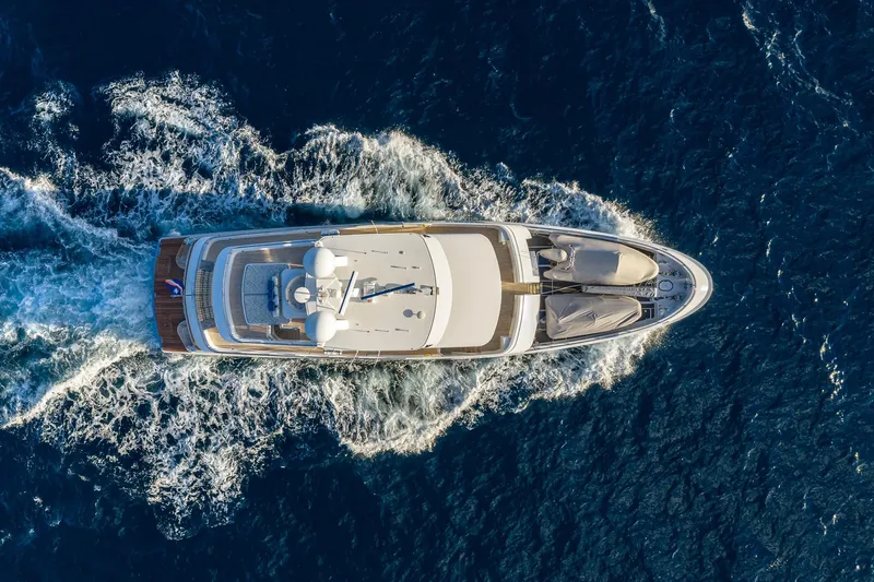  Yacht Photos Pics Aerial view of 2017 Nordhavn 96 yacht cruising through deep blue ocean waters.