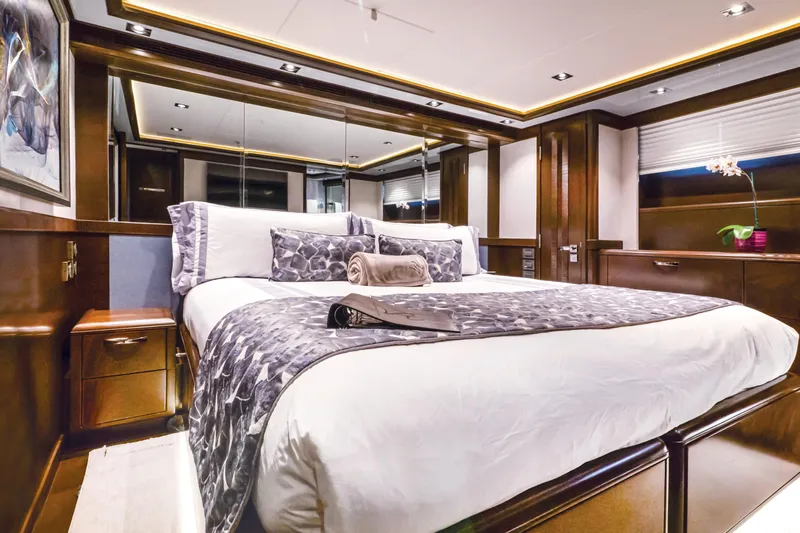  Yacht Photos Pics Luxurious bedroom interior of 2017 Nordhavn 96 yacht with elegant wood finishes and modern decor.