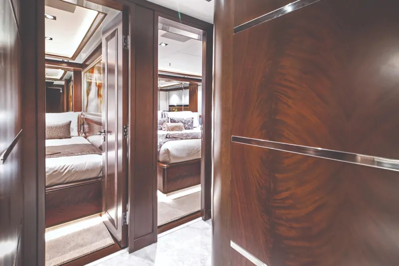  Yacht Photos Pics Luxurious interior of 2017 Nordhavn 96 yacht with elegant wood finishes and plush bedding.