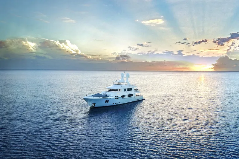  Yacht Photos Pics Luxurious 2017 Nordhavn 96 yacht cruising at sunset on tranquil ocean waters.