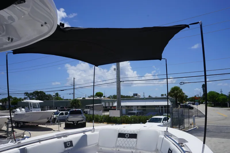  Yacht Photos Pics 2025 Sea Fox 328 Commander boat with sunshade, parked outdoors under clear blue sky.